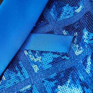 Close-up detail of blue sequin blazer fabric, smooth satin lapel and pocket trim design.