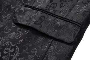 Close-up detail of black jacquard fabric, elegant floral scroll pattern and pocket design.