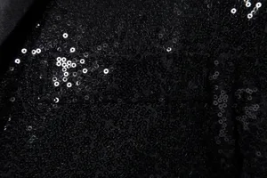 Close-up detail view of mens black sequin jacket showing sparkling sequin fabric texture.