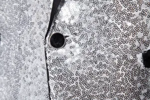 Men's sequin blazer close up detail showing silver sparkling fabric and black lapel design.