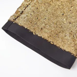 Dettaglio polsino pantaloni abito uomo paillettes oro, vista ravvicinata spettacolo.