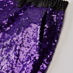 Primo piano dettagliato dei pantaloni da uomo in paillettes viola con una cintura nera.