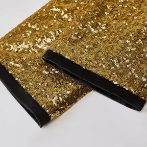 Dettaglio dei pantaloni di paillettes oro con tessuto lucido e bordo in satin nero da uomo.