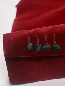 Detalle en primer plano de la manga de traje de terciopelo rojo para hombre con botones.