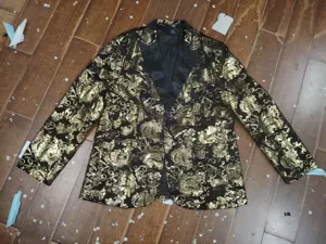 Detailed view of men's black and gold paisley suit jacket texture and fabric craftsmanship