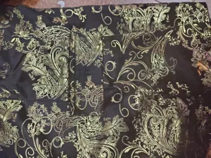 Men's suit jacket detail showing intricate gold paisley jacquard fabric texture and pocket.