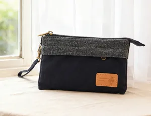 Trousse de maquillage en toile noire et tweed contrasté avec fermeture éclair, dragonne et étiquette.