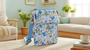 Fresh floral fabric cross-body phone bag, cozy living room scene detail view, compact design.