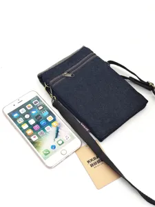 Detailed view of the dark blue denim cross-body phone bag, featuring secure zippers and strap.