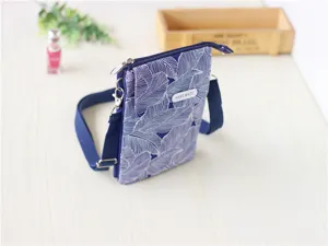 Blue leaf print fabric crossbody phone bag, detail view showing floral pattern and handmade tag.