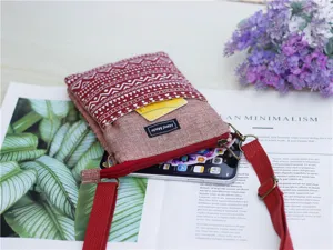 Detailed view of ethnic style canvas crossbody phone bag with geometric pattern and strap.