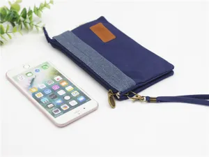 Vue détaillée de la pochette zippée multicouche en toile bleue avec lanière de poignet.