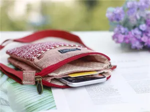 Detail view of red ethnic style fabric cross-body phone bag, multi-layer canvas design.