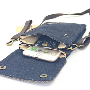 Close-up of denim cross-body phone bag showing dual compartments with phone and card inside.