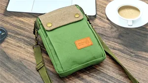 Detail view of green canvas crossbody phone bag, casual minimalist design with adjustable strap.