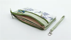 Dettaglio borsa da polso in tessuto per donna con scomparti multipli con cerniera e fiocco.