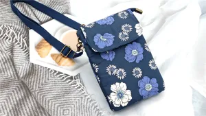 Detailed view of the blue floral crossbody phone bag with adjustable strap and rustic aesthetic.