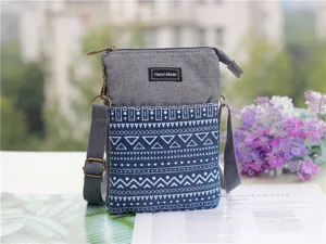 Detailed view of the ethnic style canvas crossbody phone bag with multi-layer zippers.