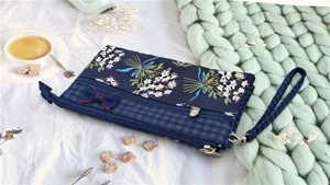 Primo piano dettagliato della borsa da polso in tessuto floreale con tasche multiple.