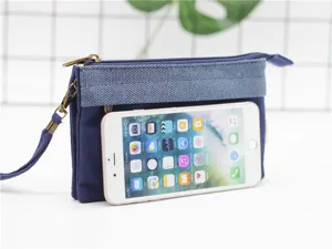Détail de pochette zippée multicouche en toile avec smartphone pour la taille.