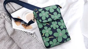 Floral fabric cross-body phone bag with clover print, adjustable strap and brass hardware.