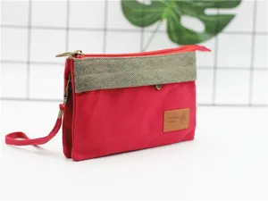 Vue de détail rapprochée de la pochette de rangement cosmétique multicouche en toile rouge et grise.