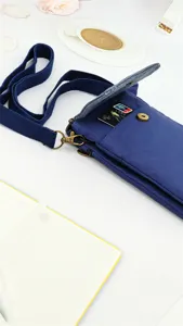 Closeup of the multi-layer canvas phone crossbody bag showing detailed pocket and hardware.
