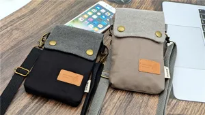 Canvas crossbody phone bag with multi-layer compartments and adjustable strap. Detail view.
