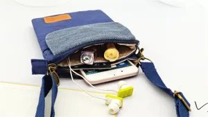 Canvas crossbody phone bag detail view, showing multi-layer storage capacity and strap.
