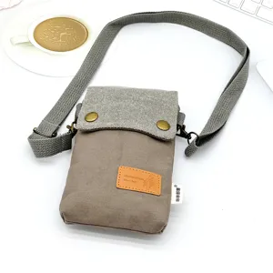Detailed view of casual canvas crossbody phone bag with adjustable strap and contrast flap design.