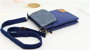 Blue canvas crossbody phone bag with multi-layer storage, adjustable strap and flap pocket.