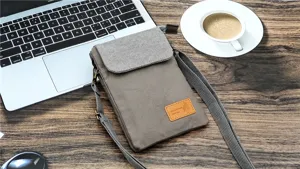 Detail view of casual canvas cross-body phone bag with textured flap and adjustable strap.