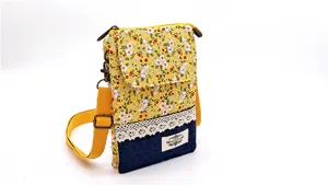 Detailed close-up view showcasing the pastoral floral fabric and denim phone bag.