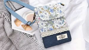 Floral print denim crossbody phone bag with lace trim and adjustable strap for women.