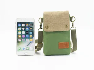 Green canvas crossbody phone bag with beige flap and metal hardware for daily travel convenience.