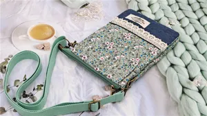 Floral fabric crossbody cell phone bag with denim patchwork, lace trim and shoulder strap.