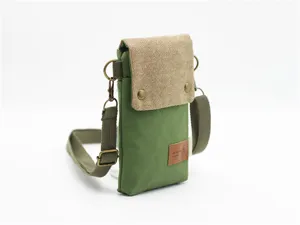 Canvas crossbody phone bag detail view, green and khaki fabric with metal hardware and strap.