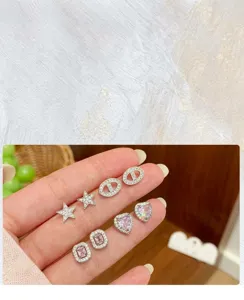 Vue détaillée de l'ensemble de boucles d'oreilles en zircon étincelant aux formes tendance.