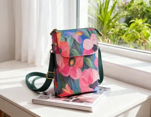 Floral crossbody phone bag detail, green strap and vibrant print for casual outdoor use.