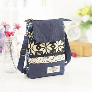 Denim canvas cross-body phone bag with ethnic geometric pattern and lace trim. Stylish mini bag.