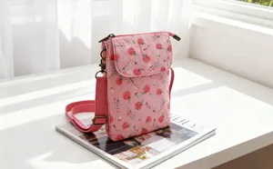 Detail view of the pink floral crossbody phone bag with cute fruit pattern and shoulder strap.
