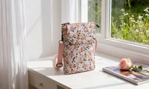 Floral fabric crossbody phone bag detail view, showing the delicate floral pattern and strap.