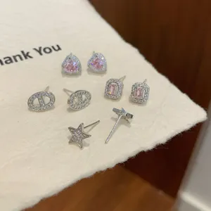 Joli set de boucles d'oreilles en argent avec oxydes de zirconium, cœurs et formes géométriques.