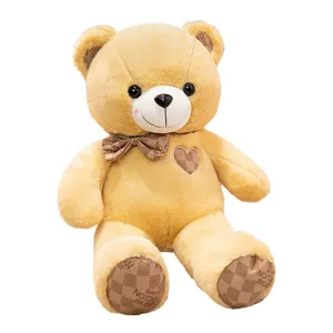 Cute teddy bear plush toy with bowtie and heart patch. Soft stuffed animal gift for kids.