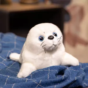 Cute white seal plush toy detail close-up showing sparkly blue eyes and soft stuffed fur.