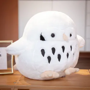 Cute white round owl plush toy close-up, soft fluffy texture, cute black belly spots and beak.