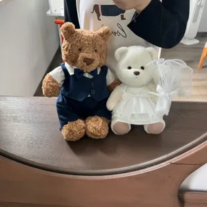 Detailed view of teddy bear couple plush toys wearing wedding suit and white dress outfit.