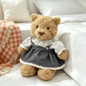 Cute plush teddy bear doll wearing stylish white polka dot blouse and grey dress set for decoration.