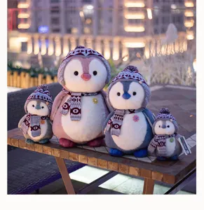 Cute penguin plush toy detail shot featuring knitted winter scarves and hats for kids.