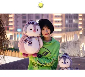 Cute penguin plush toy with knitted hat and scarf, soft stuffed doll gift for kids.